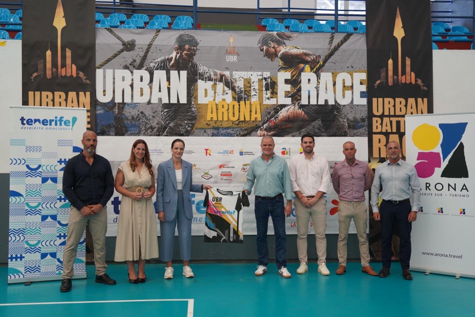 La presentación oficial de la Urban Battle Race 2024 reúne a más de 700 corredores de 22 países

Ayer, miércoles 9 de octubre, se celebró con éxito la rueda de prensa de presentación de la Urban Battle Race 2024. La carrera de batalla urbana ofrece el dato destacado de la notable participación femenina, un 41,7%.

A las 8:30 de la mañana para en distintas tandas de salida, desde el complejo polideportivo Jesús Domínguez Grillo, para superar más de 50 obstáculos en las modalidades Elite, 12k, 8k y 5k, de forma individual, en parejas o en equipo.

Los organizadores expresaron su entusiasmo por el nivel de participación internacional y la diversidad de los atletas inscritos, lo que garantiza una competencia vibrante y dinámica. La carrera se desarrollará en un entorno urbano especialmente diseñado para ofrecer una experiencia única a los corredores y al espectador.

Se espera una jornada inolvidable, llena de adrenalina, superación y espíritu deportivo, gracias a Promotur Islas Canarias, DXT Deportes Tenerife, el Exmo. Ay. De Arona, la concejalía de Deportes de Arona y la concejalía de Turismo de Arona.
