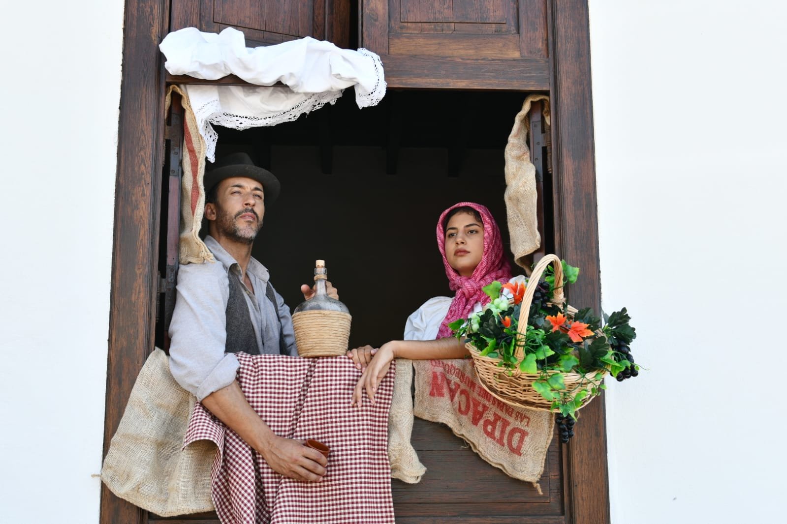 Arona en Tradiciones 2024 revivirá los años 40 y 50 del siglo XX con una experiencia inmersiva

Este viaje al pasado incluirá recreaciones teatrales, exposiciones, feria gastronómica, mercado de artesanía, poesía y numerosas actuaciones musicales. El mismo sábado, el Conjunto Histórico de Arona también acogerá la celebración del Día del Mayor, con más de 400 participantes.

Ya está todo listo para la edición 2024 de ‘Arona en Tradiciones’, una auténtica experiencia inmersiva que permitirá revivir en diversos rincones y calles del Bien de Interés Cultural (BIC) del Conjunto Histórico de Arona los usos y costumbres de los años 40 y 50 del pasado siglo XX. El evento es organizado por el Patronato de Turismo del Ayuntamiento de Arona que dirige Dácil León con la colaboración de las áreas de Patrimonio Histórico Cultural (gestionada por Luis García) y Fiestas (a cargo de Alexis Gómez), y forma parte de los actos populares de las Fiestas Mayores del municipio en honor al Santísimo Cristo de la Salud y Nuestra Señora la Virgen del Rosario.

Desde las 11.00 hasta las 22:00 horas del sábado, este viaje en el tiempo incluirá representaciones teatralizadas y recreaciones de escenas de época, feria gastronómica, numerosas exposiciones, mercado de artesanía, parrandas, baile y multitud de espectáculos y actuaciones folclóricas, así como ópera y un concierto de piano. Habrá maridajes y catas de vino con música y poesía, así como degustaciones de gastronomía local y canaria. El público infantil, además, podrá disfrutar de talleres, juegos tradicionales y espectáculos.

Se revivirán oficios tradicionales y quehaceres vinculados a la agricultura y el empaquetado de tomates; moliendas de gofio, venta itinerante de pescado o labores de costura, calados y rosetas. Se abrirán al público las puertas de la Casa de la Bodega y la Casa de los Baute, inmuebles de valor histórico que complementarán este salto en el tiempo. Saldrán del olvido objetos que han ido cayendo en desuso: muebles, enseres y adornos domésticos, mantelerías y textiles, útiles de labranza y, entre otros, fotos y cuadros. Además, volverán a circular vehículos y motos clásicas. Y volverán a sonar con normalidad expresiones y palabras venidas del pasado.

La música sonará por prácticamente todas las esquinas del casco histórico de Arona de la mano de Félix Morales, Isabel González, la orquesta Venxamar y el grupo de baile La Chaveña, la pianista Yasmina Gallardo, la Parranda Villera Comer y Cantar y las agrupaciones folclóricas Amigos de Punta Rasca, Igara, Verodal y Herederos de Chasna. También se podrá disfrutar de la orquesta Brisas de Arona, Vinomios Folk, la soprano Sislena Caporroso, Al Sur y Añate, así como de Ernesto Rodríguez Abad, Ayla Rodríguez y Mateo Felipe (El Salinero). El cierre del evento correrá a cargo de La Parranda Chasnera a partir de las 20.30 horas en la plaza de la iglesia.

Para facilitar los traslados se habilitará servicio gratuito de guagua desde Playa de Las Américas (parada en el Zentral Center), Los Cristianos (Auditorio Infanta Leonor), Buzanada (explanada del campo de fútbol) y Cabo Blanco (explanada del centro de salud). El transporte de ida será de 12:00 a 13:00 horas, y el de vuelta partirá de la Plaza de la Paz de 16:00 a 18:00 horas.

Día del Mayor: otro evento importante también en el casco

De forma paralela, el casco histórico de Arona también acogerá ese día la celebración del Día del Mayor. Más de 400 personas de los once centros de mayores del municipio disfrutarán de un almuerzo y la actuación del Trío Acorde en el colegio público del núcleo.