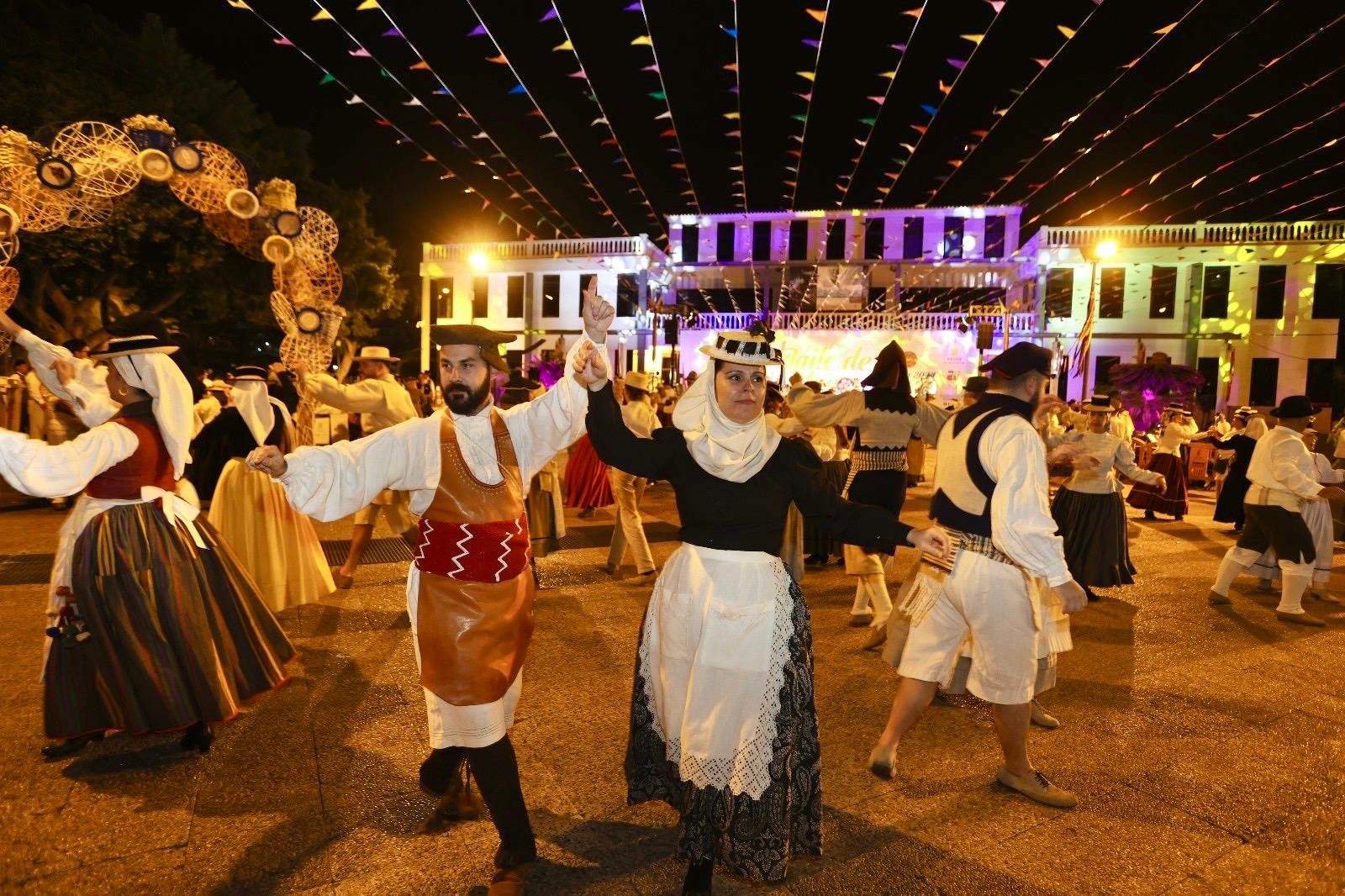 Arona celebra el Día de Canarias con una semana llena de tradición y folclore. El Baile de Magos en conmemoración del Día de Canarias tendrá lugar el jueves a partir de las 21:30 horas en el exterior del Centro Cultural de Los Cristianos.
El Ayuntamiento de Arona, a través de su Patronato de Cultura, conmemora el Día de Canarias con una agenda llena de música, folclore y tradición que serán la antesala de la gran noche canaria con el Baile de Magos organizado por las Concejalías de Fiestas y Cultura.
Este lunes, 26 de mayo, el Auditorio Infanta Leonor de Los Cristianos acoge el concierto Canarias Fusión Antología a partir de las 20:00 horas, un espectáculo musical con un variado cartel de artistas. La entrada es gratuita con invitación que se puede obtener en arona.ticketary.es/ o en el Centro Cultural de Los Cristianos.
El martes 27 de mayo, tendrá lugar el espectáculo ‘El Folclore en Arona’, que contará a las 20:00 horas y en el escenario del Auditorio Infanta Leonor de Los Cristianos con las actuaciones de A.C. Igara, A.C. Herederos de Chasna, A. C. Punta Rasca y la Escuela Municipal de Folklore de Arona. La entrada es gratuita con invitación que se puede obtener en arona.ticketary.es/ o en el Centro Cultural de Los Cristianos.
En el mismo escenario, el miércoles 28 de mayo, la Asociación Cultural Verodal presenta su espectáculo ‘Mararía, Ecos de la Tierra’ con la participación de Lola Hernández, Marcos Luis y Pablo Díaz, a las 20:30. La entrada es gratuita con invitación que se puede obtener en arona.ticketary.es/ o en el Centro Cultural de Los Cristianos.
El Baile de Magos en conmemoración del Día de Canarias Arona 2025 tendrá lugar este jueves, desde las 21:30 y hasta las 03:30 horas, en el exterior del Centro Cultural de Los Cristianos con la organización de la Concejalía de Fiestas y del Patronato de Cultura. La celebración contará con las actuaciones de los grupos Parranda del Ron, A.C. Verodal, A.F. Herederos de Chasna, A.C. Vinomio Folk, A.F. I’Gara, A.F. Amigos de Punta Rasca, A.C. Al Sur, la Escuela Municipal de Folklore de Arona y Aparrandados.
Para la asistencia al baile de magos es imprescindible vestir el traje tradicional y es recomendable llevar comida para compartir. La reserva de mesas se puede realizar hasta el 27 de mayo en la recepción del Centro Cultural de Los Cristianos.
El viernes 30 de mayo, Día de Canarias, la Concejalía de Promoción Económica ha organizado en el Mercado del Agricultor de Valle San Lorenzo una jornada especial en la que habrá una degustación de productos típicos canarios. Además, contarán con la actuación musical de la A.F.
