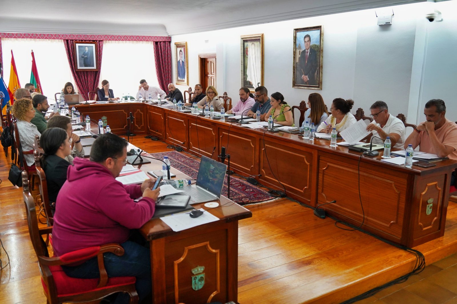 El Pleno Municipal de Arona aprobó la cesión de terrenos para la creación de dos nuevos centros educativos y la regularización de viviendas sociales. Además, se dio el visto bueno para que GESPLAN pase a ser un medio propio personificado del Ayuntamiento con el fin de mejorar la eficiencia en la prestación de servicios.

El Ayuntamiento de Arona ha iniciado el proceso de cesión de parcelas municipales a la Consejería de Educación del Gobierno de Canarias para la construcción de un Centro de Educación Especial y Residencia Escolar en Parque La Reina, así como un Centro Integral de Formación Profesional en Los Cristianos. Estos proyectos forman parte del Plan de Choque de la Consejería de Educación, que también incluye la ampliación y mejora de otros cinco centros educativos en Arona.

Por otro lado, el Pleno aprobó ceder al Instituto Canario de la Vivienda (ICAVI) el suelo de las viviendas sociales de Vento y Hermano Pedro para desbloquear las trabas administrativas que han retrasado su entrega durante 38 años. Este acuerdo histórico permitirá a los vecinos escriturar sus viviendas y beneficiarse de servicios públicos esenciales en sus zonas comunes.

Además, el Pleno acordó solicitar a GESPLAN, la entidad pública autonómica, la mejora de la eficiencia y eficacia en la prestación de servicios en el municipio de Arona. Acuerdo para mejorar eficiencia en servicios municipales en Arona.
