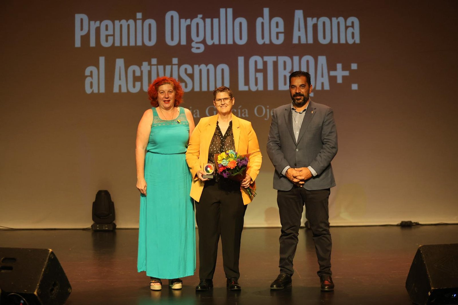 La Gala ‘Orgullo de Arona 2025’ premia el activismo LGTBIQA+
Los premios a referentes como Patricia Ojeda, Romina Magdalena y Rosario Miranda destacan en la semana ‘Arona Vive con Orgullo’. El Auditorio Infanta Leonor de Los Cristianos acogió la emotiva Gala ‘Orgullo de Arona 2025’, enmarcada en la Semana del Orgullo LGTBIQA+. Reconociendo la lucha y trayectoria de personas clave del colectivo LGTBIQA+, la gala contó con actuaciones festivas y reivindicativas. Patricia Ojeda recibió el ‘Premio Orgullo de Arona al Activismo’, Romina Magdalena el ‘Premio Orgullo de Arona a la Visibilidad’, y Rosario Miranda el ‘Premio Orgullo de Arona Honorífico’. Tras el izado de la bandera LGTBIQA+ y la lectura del manifiesto, la Gala puso fin a la Semana del Orgullo en Arona.