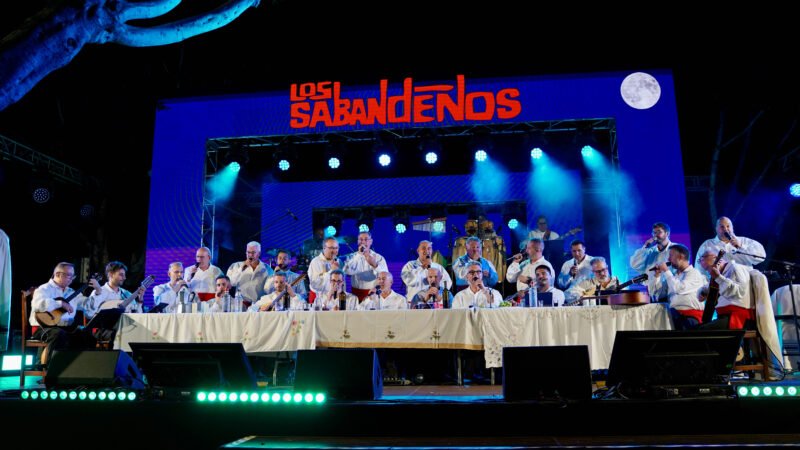 Arona celebra un comienzo emocionante y multitudinario de sus Fiestas Mayores 2025

Las Fiestas Mayores 2025 en honor al Santísimo Cristo de la Salud y Nuestra Señora del Rosario han comenzado en Arona con un fin de semana cargado de emoción y participación vecinal. El viernes 26 de septiembre se llevó a cabo la lectura del pregón a cargo de Patricia León Alayón en la Plaza del Santísimo Cristo de la Salud, seguido por la presentación de las candidatas a reina y la actuación del Trío a Mi Manera.

El sábado 27 se inauguró la exposición colectiva ‘Pintura y Escultura de Artistas en Arona’ y la muestra “Programas de las Fiestas desde 1959 hasta la actualidad” en el Ayuntamiento de Arona. Por la noche, la Noche Latina en la plaza contó con las actuaciones de Quimbao La Nuit, Swing Latino, DJ David Pérez y el tributo a Marc Anthony ‘Yo Marc’, entre otros artistas.

El domingo 28, Los Sabandeños celebraron su 60 aniversario con un emotivo concierto en la plaza, brindando un espectáculo cargado de tradición y música canaria.

Las Fiestas Mayores continuarán en los próximos días con un programa lleno de eventos destacados, incluyendo una tarde infantil con castillos hinchables, talleres y el espectáculo infantil La Reina de la Fantasía, el musical. La semana culminará con la coronación de la Reina por la Infancia, la Reina Municipal de los Mayores y la Reina de las Fiestas Mayores de Arona, eventos que reflejan la tradición y el sentimiento que caracterizan a estas celebraciones.