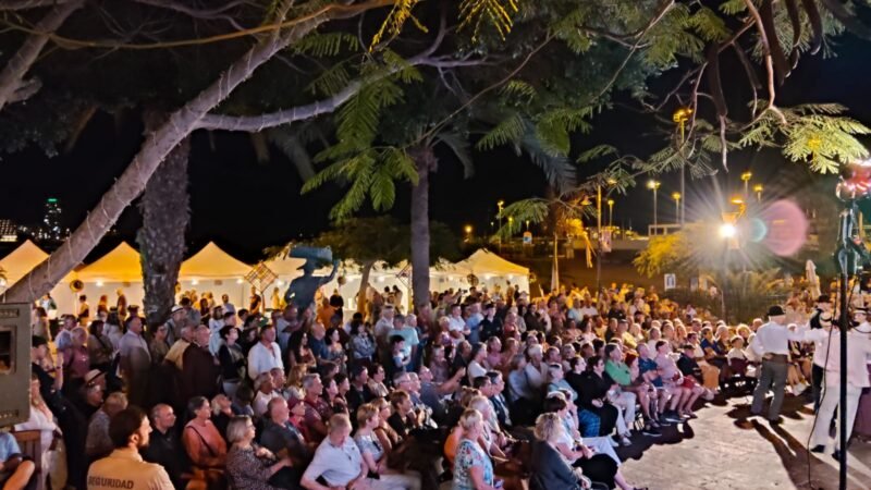 El Festival Folclórico de Arona da inicio a su edición 2025-2026 en Los Cristianos

El Festival Folclórico de Arona ha comenzado su nueva edición en el Paseo Marítimo de Los Cristianos, llenando el lugar de música, tradición y turismo. El evento, organizado por la Concejalía de Cultura, Turismo y Patrimonio Histórico, inauguró la celebración con un emotivo acto que combinó música, artesanía y gastronomía local.

Desde tempranas horas, la feria de artesanía abrió sus puertas para mostrar el talento de los artesanos locales. Los pasacalles folclóricos de los grupos Verodal, Herederos de Chasna e I’Gara llenaron el ambiente de música y alegría, con la participación entusiasta de vecinos y visitantes.

El concejal de Cultura, Turismo y Patrimonio Histórico, Naím Yánez Alonso, dio la bienvenida a los asistentes destacando la importancia de las tradiciones locales. Durante el evento se homenajeó a los artesanos participantes, reconociendo su contribución a la preservación de las tradiciones locales.

La Escuela Municipal de Folclore de Arona y la Agrupación Folclórica Amigos de Punta Rasca fueron las encargadas de ofrecer actuaciones musicales, cerrando una noche llena de emoción y orgullo local.

El Festival Folclórico de Arona se llevará a cabo todos los jueves, con feria artesanal a partir de las 16:00 horas y actuaciones folclóricas a las 19:30 horas.