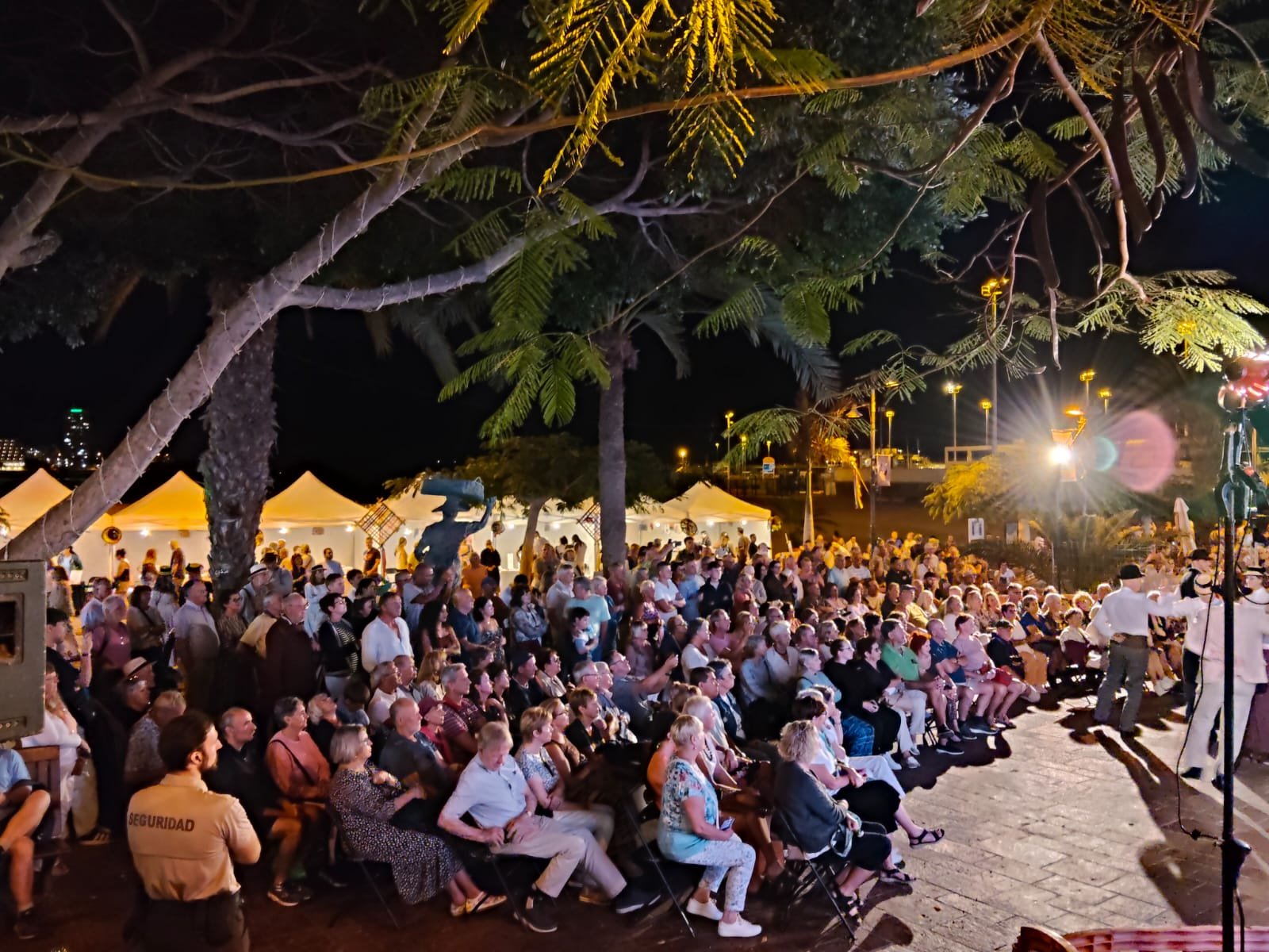 El Festival Folclórico de Arona da inicio a su edición 2025-2026 en Los Cristianos

El Festival Folclórico de Arona ha comenzado su nueva edición en el Paseo Marítimo de Los Cristianos, llenando el lugar de música, tradición y turismo. El evento, organizado por la Concejalía de Cultura, Turismo y Patrimonio Histórico, inauguró la celebración con un emotivo acto que combinó música, artesanía y gastronomía local.

Desde tempranas horas, la feria de artesanía abrió sus puertas para mostrar el talento de los artesanos locales. Los pasacalles folclóricos de los grupos Verodal, Herederos de Chasna e I’Gara llenaron el ambiente de música y alegría, con la participación entusiasta de vecinos y visitantes.

El concejal de Cultura, Turismo y Patrimonio Histórico, Naím Yánez Alonso, dio la bienvenida a los asistentes destacando la importancia de las tradiciones locales. Durante el evento se homenajeó a los artesanos participantes, reconociendo su contribución a la preservación de las tradiciones locales.

La Escuela Municipal de Folclore de Arona y la Agrupación Folclórica Amigos de Punta Rasca fueron las encargadas de ofrecer actuaciones musicales, cerrando una noche llena de emoción y orgullo local.

El Festival Folclórico de Arona se llevará a cabo todos los jueves, con feria artesanal a partir de las 16:00 horas y actuaciones folclóricas a las 19:30 horas.