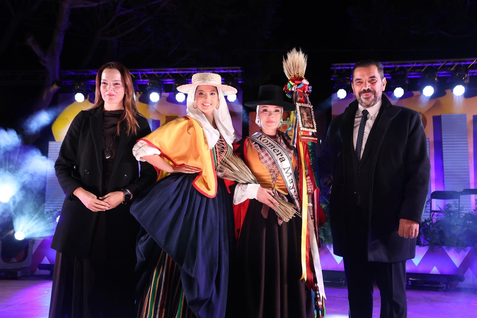 Arona elige a su Romera Mayor para las Fiestas Patronales y Romería en Honor a San Antonio Abad 2026

La elección de la Romera Mayor para las Fiestas Patronales y Romería en Honor a San Antonio Abad 2026 en Arona fue un evento lleno de tradición y emoción. La Plaza del Santísimo Cristo de la Salud fue el escenario de esta gala tan esperada, que marca el comienzo de una de las celebraciones más importantes del municipio.

En la noche del jueves, Arona vivió uno de los momentos más cargados de emoción con la celebración de la Gala de Elección de la Romera Mayor y su Corte de Honor. El evento tuvo lugar en la Plaza del Santísimo Cristo de la Salud, en Arona Casco, y llevó por título «Hijos del Barro», en homenaje a la tradición alfarera y a los oficios ligados a la tierra que son símbolos del esfuerzo y la identidad de generaciones de aroneras y aroneros.

Ariadna Alayón Melo, representante de Los Cristianos, fue proclamada Romera Mayor 2026 después de la deliberación del jurado. Durante la gala, recibió la banda que la acredita como Romera Mayor de manos de la alcaldesa de Arona, Fátima Lemes Reverón, y del concejal de Fiestas, Alexis Gómez. Además, recibió la Vara de Romera de la Romera Mayor saliente, Náyade Vargas González, como símbolo de continuidad y tradición.

Junto a la Romera Mayor, también se presentaron las candidatas: Ainoha Martín Reyes (Arona Casco), Wendy Tagore Afonso (El Fraile), Nayara Sánchez Pinto (Cabo Blanco) y Nayara Gerpe Mora (Guargacho). Todas recibieron su Vara de Romera, símbolo de compromiso, identidad y orgullo al representar a sus respectivos pueblos y barrios en una de las celebraciones más emblemáticas de Arona.

Durante la gala, se rindió un emotivo homenaje a Juan Manuel Pérez, conocido como «Meme», en agradecimiento por su contribución a la conservación y difusión de las tradiciones y la cultura popular de Arona.

El evento contó con las actuaciones de Non Trubada, Iván Quintana, Ballet The Kaizer y la A.F.