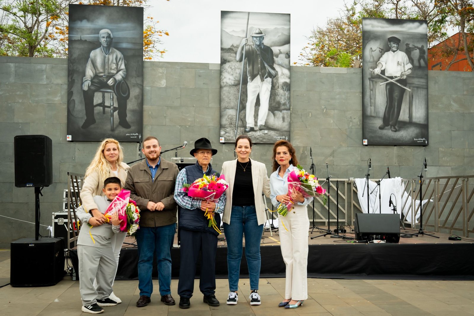 El pasado sábado, El Fraile se vistió de gala para rendir homenaje a tres ilustres vecinos: don Salvador González, don Eduardo Alayón y don Gabriel Rancel. La jornada estuvo llena de actividades culturales y artísticas que celebraron la vida y legado de estos destacados miembros de la comunidad.

Entre las actividades programadas se incluyeron la inauguración de un mural en la Plaza de El Fraile con la imagen de los homenajeados, un pasacalles, exhibición de tradiciones locales, taller de pintura, recital de poesía, presentaciones folclóricas y un emotivo concierto de clausura.

El evento, titulado ‘Raíces Creativas, El Fraile en Arte’, fue organizado por el área de Cultura del Ayuntamiento de Arona y contó con la colaboración de la asociación de Lobos del Asfalto, residente en El Fraile. La jornada se llevó a cabo en el Centro Cívico Eduardo Oramas Alayón y reunió a personas de todas las edades para disfrutar de la rica oferta cultural y artística local.

La tarde dio inicio a las 16:00 horas con la apertura de la exposición mural a cargo del talentoso artista local Dani Paint, que embelleció el entorno del centro cívico con su obra. Una tarde llena de emoción y arte en honor a la memoria de tres grandes figuras de El Fraile.